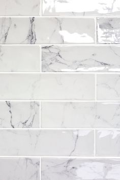 a white marble tile wall that looks like it is being used as a backsplash