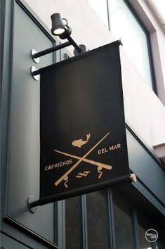 a black sign hanging from the side of a building