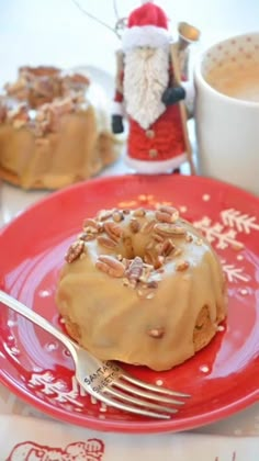 a red plate topped with a donut covered in frosting next to a cup of coffee