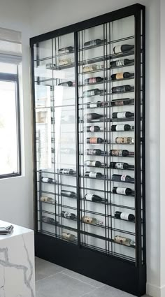 a large display case filled with lots of bottles in a room next to a window