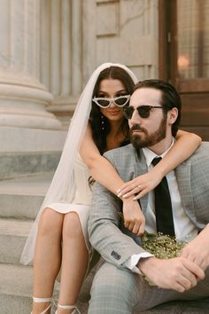 a bride and groom are sitting on the steps