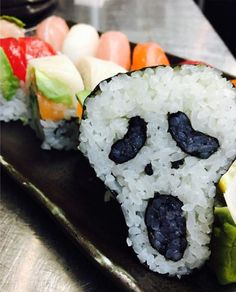 there is sushi on the plate with rice and vegetables in it, as well as an animal face