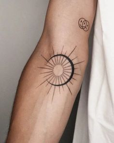 a person with a tattoo on their arm that has a sun and moon in it