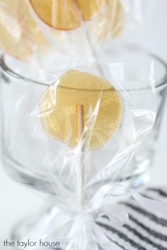 an apple is wrapped in plastic and sitting in a glass bowl