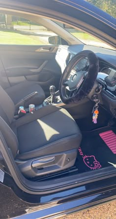 the interior of a car with an animal keychain and steering wheel in it