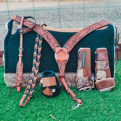 a bag with many items on it sitting in the grass