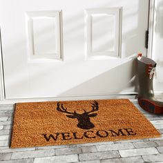 a welcome mat with a deer head on it next to a pair of rubber boots