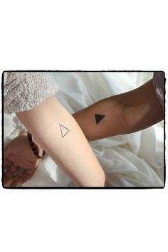 a woman with a tattoo on her arm holding onto the arm of another person's arm