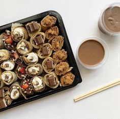 a tray filled with food next to a cup of coffee and two chopsticks