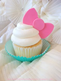 there is a cupcake with a pink bow on it