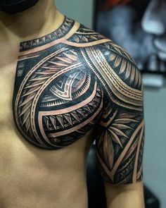 a man's chest with an intricate tattoo design on his arm and shoulder,