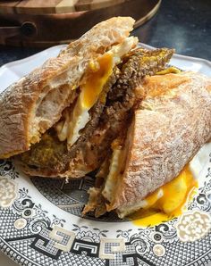 a sandwich is cut in half on a blue and white plate with an ornate design