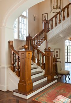 a staircase in a house with wooden handrails and carpeted flooring on either side