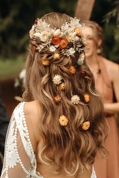 the back of a woman's head with flowers in her hair and two other women behind her