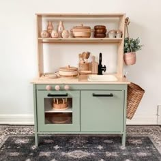 an old fashioned wooden play kitchen with lots of pots and pans on the shelves