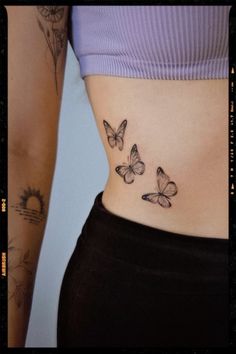 a woman's stomach with three butterflies on her lower body and the bottom part of her abdomen