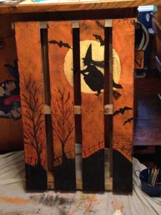 an old wooden crate with halloween decorations on it and bats flying over the moon in the background