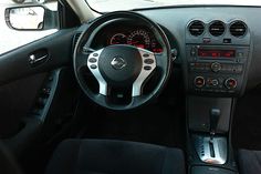 the interior of a car with black leather seats and dashboard controls, including steering wheel