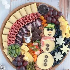 a platter filled with cheese, fruit and crackers