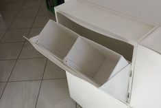 an open drawer in the middle of a tiled floored room with white walls and tile floors