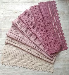 four crocheted placemats sitting on top of a wooden table