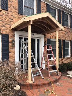 two ladders are attached to the side of a house with a roof over it