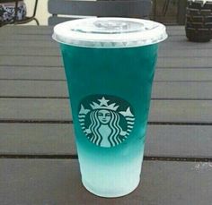 a starbucks cup sitting on top of a wooden table