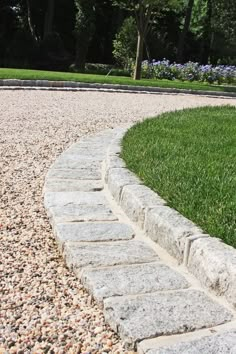 a stone path in the middle of a grassy area