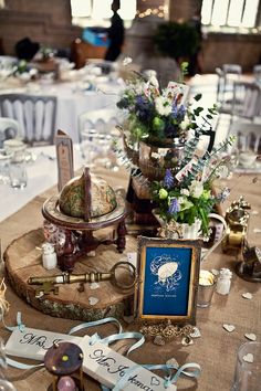 the table is set up for a formal function with flowers and other items on it