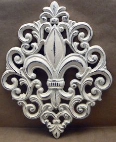 a silver fleur de lis on a brown background