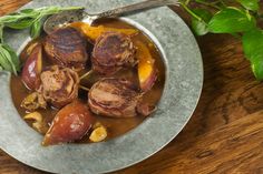 some meat and potatoes in a gravy on a plate