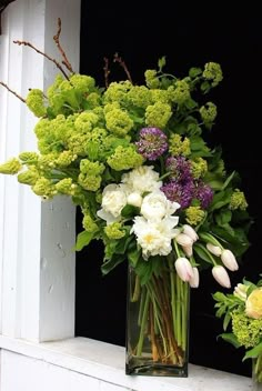 two vases filled with flowers sitting on a window sill