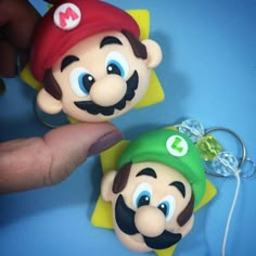 there are two mario and luigi keychains in the shape of people's heads