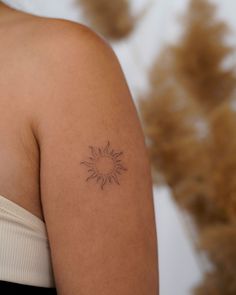 a woman's arm with a tattoo on it that has a sun in the middle