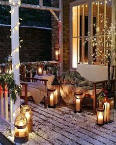 a porch covered in snow with lit candles