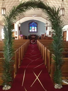 the inside of a church with red carpeting and palm trees in front of it