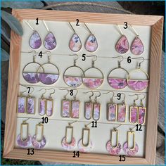 an assortment of earrings displayed in a wooden frame