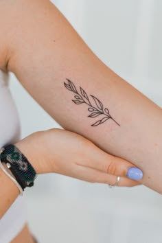 a woman's arm with a small tattoo on it