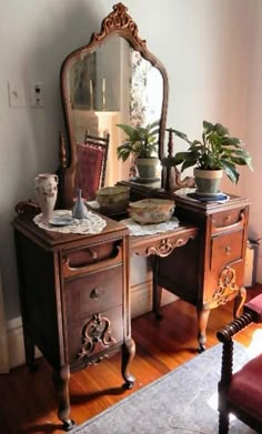 an antique dresser with mirror and potted plants