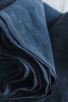 a close up view of the fabric on a bed with blue sheets and pillow cases