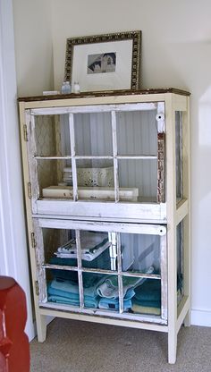 an old white cabinet with glass doors