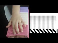 a person's hand on top of a pink binder next to a black and white checkered background