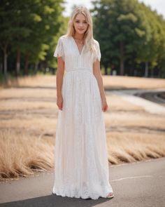 a woman in a white dress standing on a path