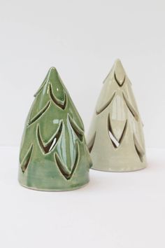 two ceramic christmas trees sitting next to each other