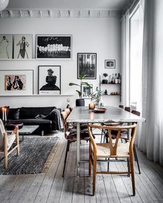 a living room filled with furniture and pictures hanging on the wall over a table in front of a couch