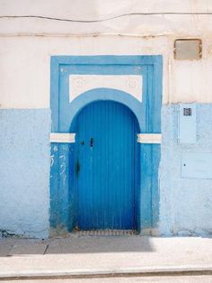 a blue and white building with an arched doorway