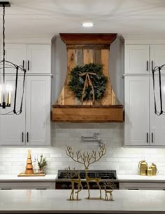 a kitchen decorated for christmas with wreath on the hood