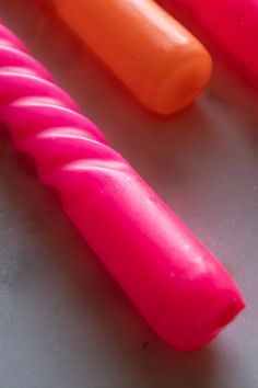 three different colored toothbrushes on a table