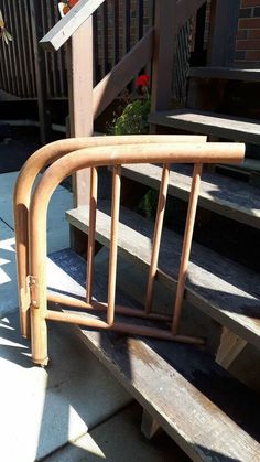 a set of wooden stairs with handrails next to flowers on the steps outside