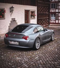 a silver sports car parked in front of a house